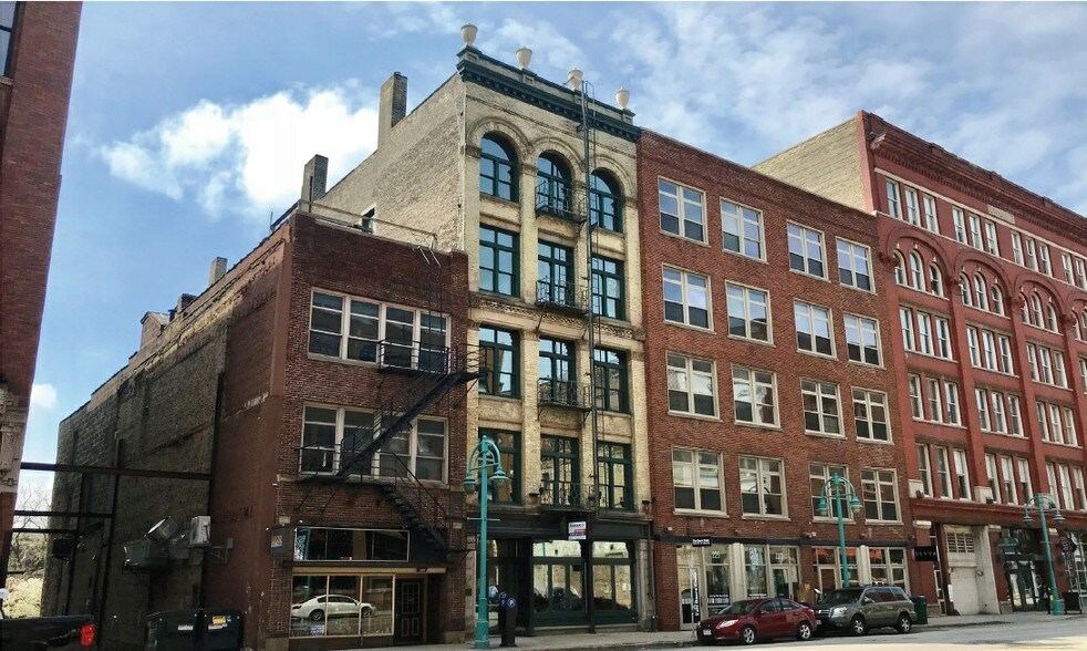 223 N. Water Street from across the street, showing the arched windows and the neighboring brick buildings.