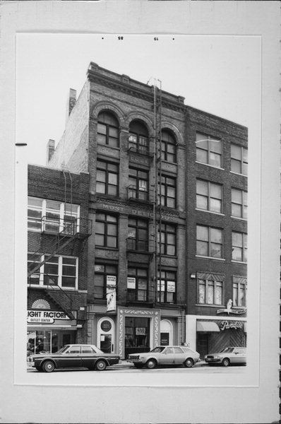Archival black and white photograph of 223 N. Water Street showing the arched upper windows and storefronts before renovation.